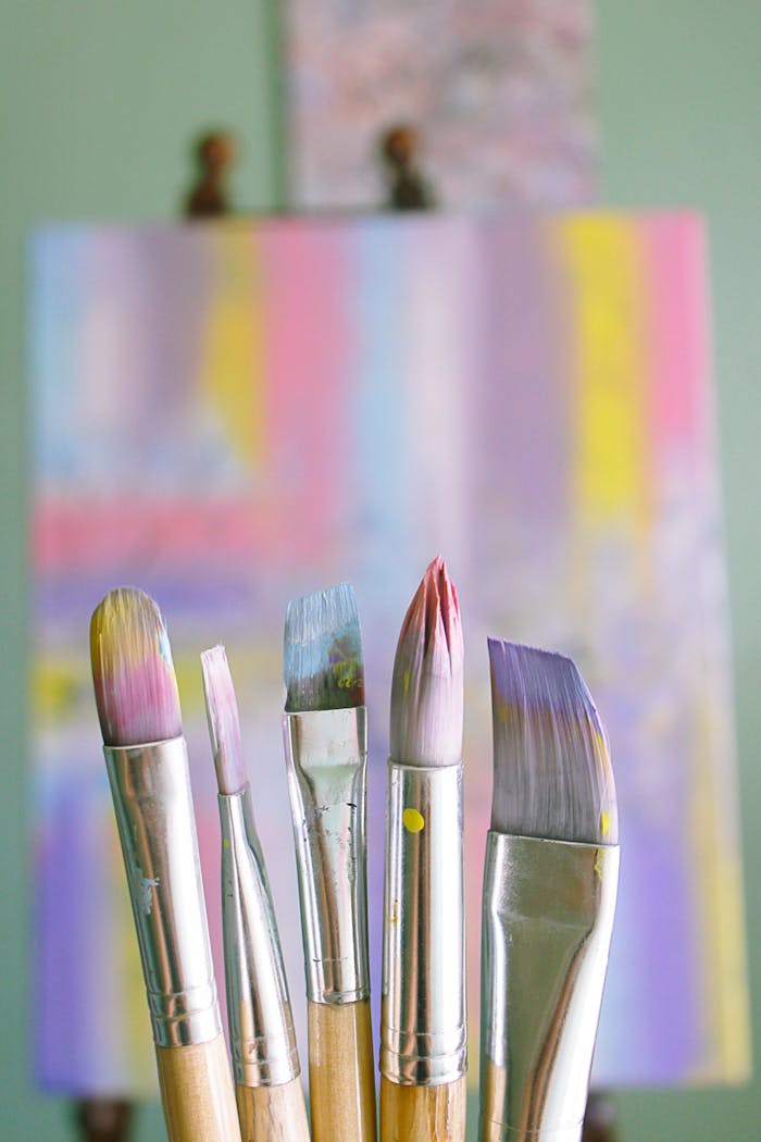 Art brushes with abstract painted canvas in vibrant colors.